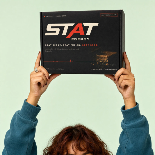 Person holding up the black STAT Shift Survival Kit box